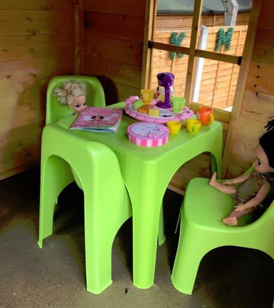 Plastic doll playset in a raised wooden playhouse